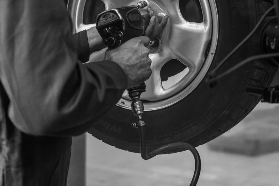 Automotive Half Inch Torque Wrench mechanic using half inch drive torque wrench on car wheel hub axle nut