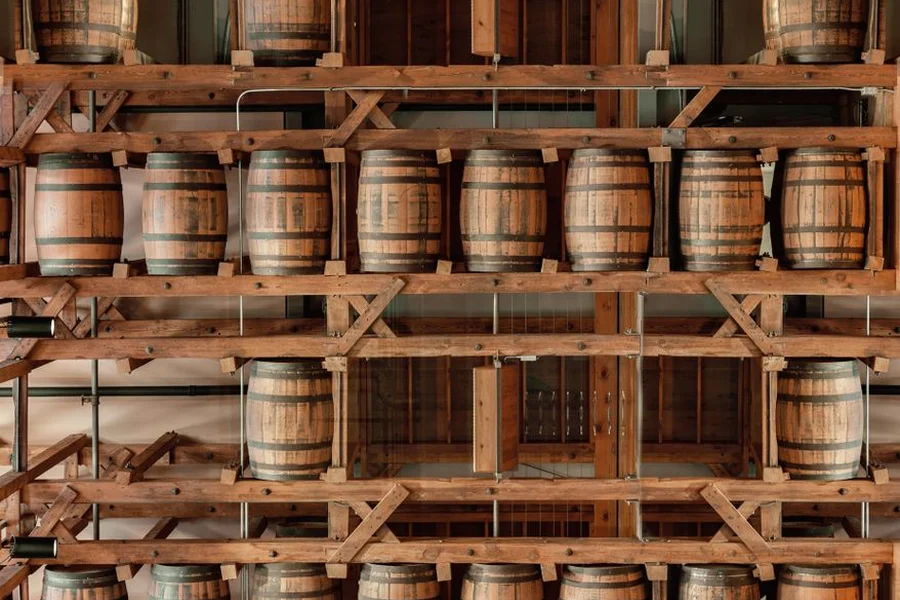 bourbon barrels resting inside historic wooden rickhouse in kentucky