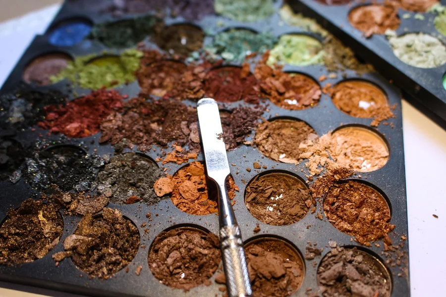 makeup artist mixing pigments palette close up