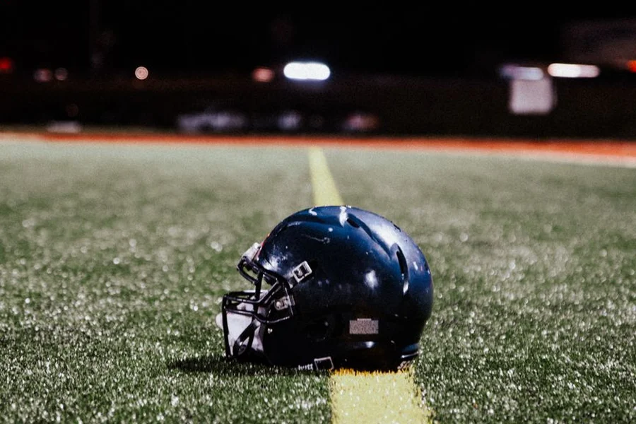 american football stadium illuminated under bright stadium lights during night game