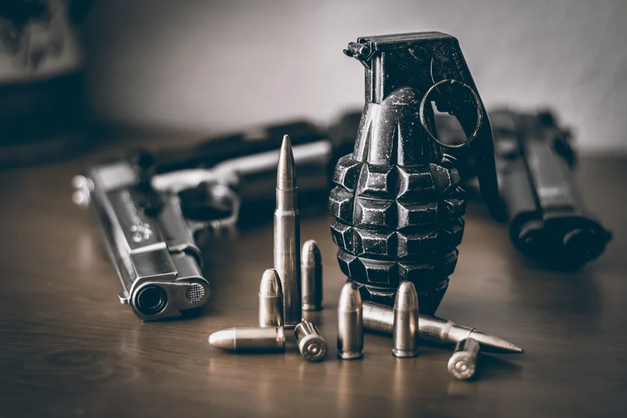 metal denix m1911a1 replica pistol resting on wooden table next to vintage military gear