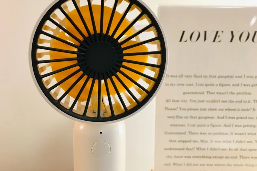 Desktop Evaporative Cooling Fan on Table Small desktop portable cooling fan running on wooden table near window