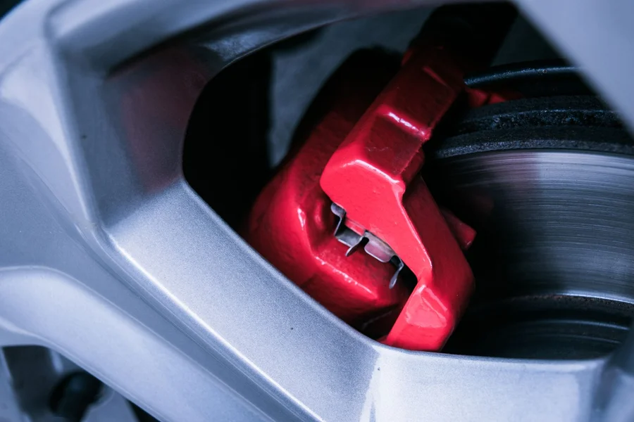Chrome pickup truck wheel and high performance red brake caliper on vehicle