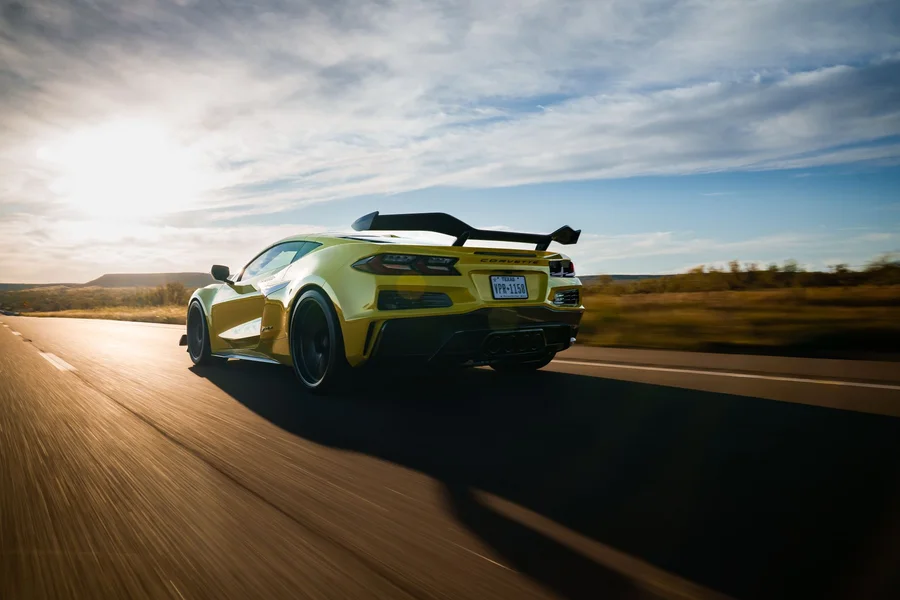 Yellow muscle pickup truck parked on asphalt road during golden hour sunset